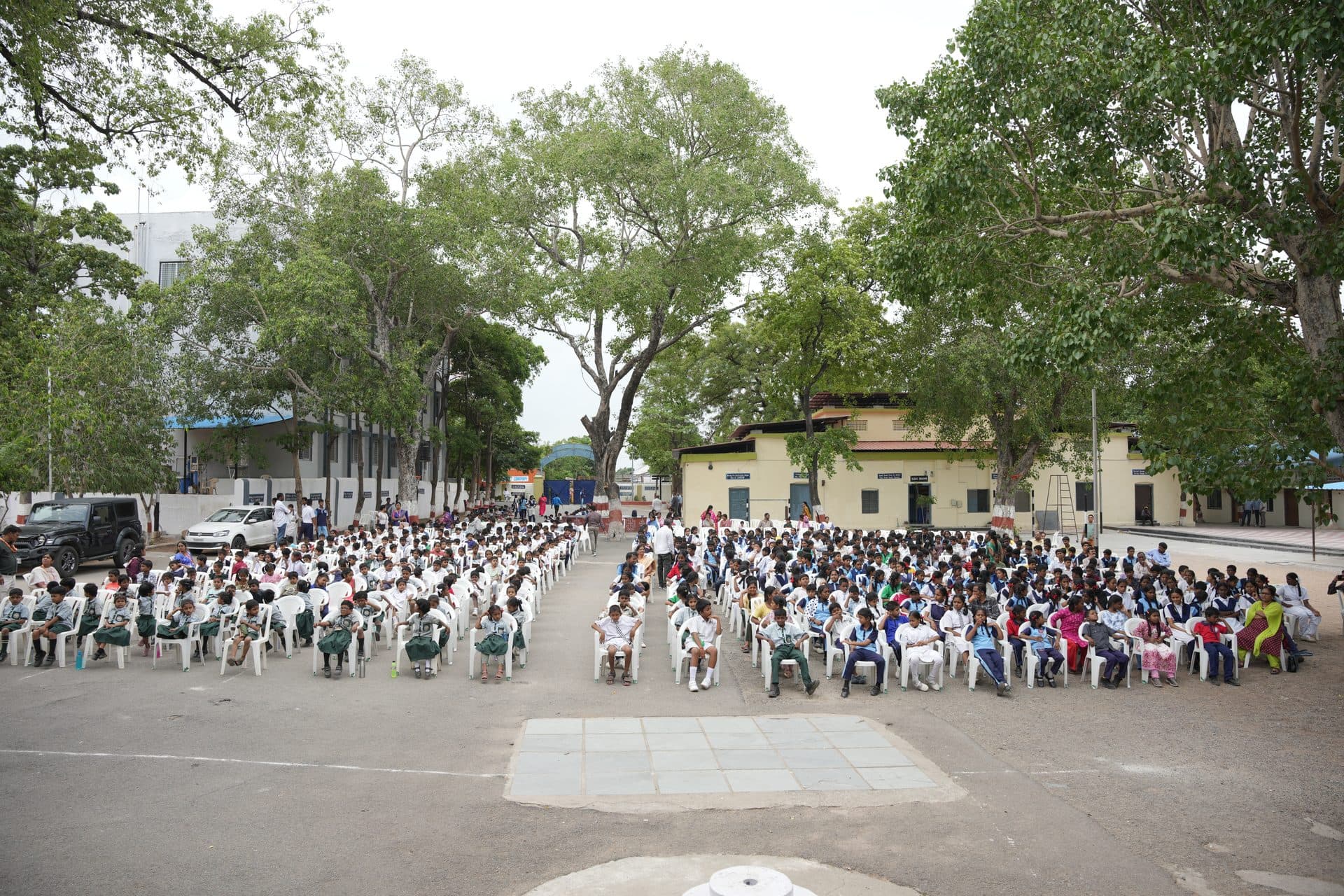 Wide view of the school grounds with the assembly area and surrounding buildings