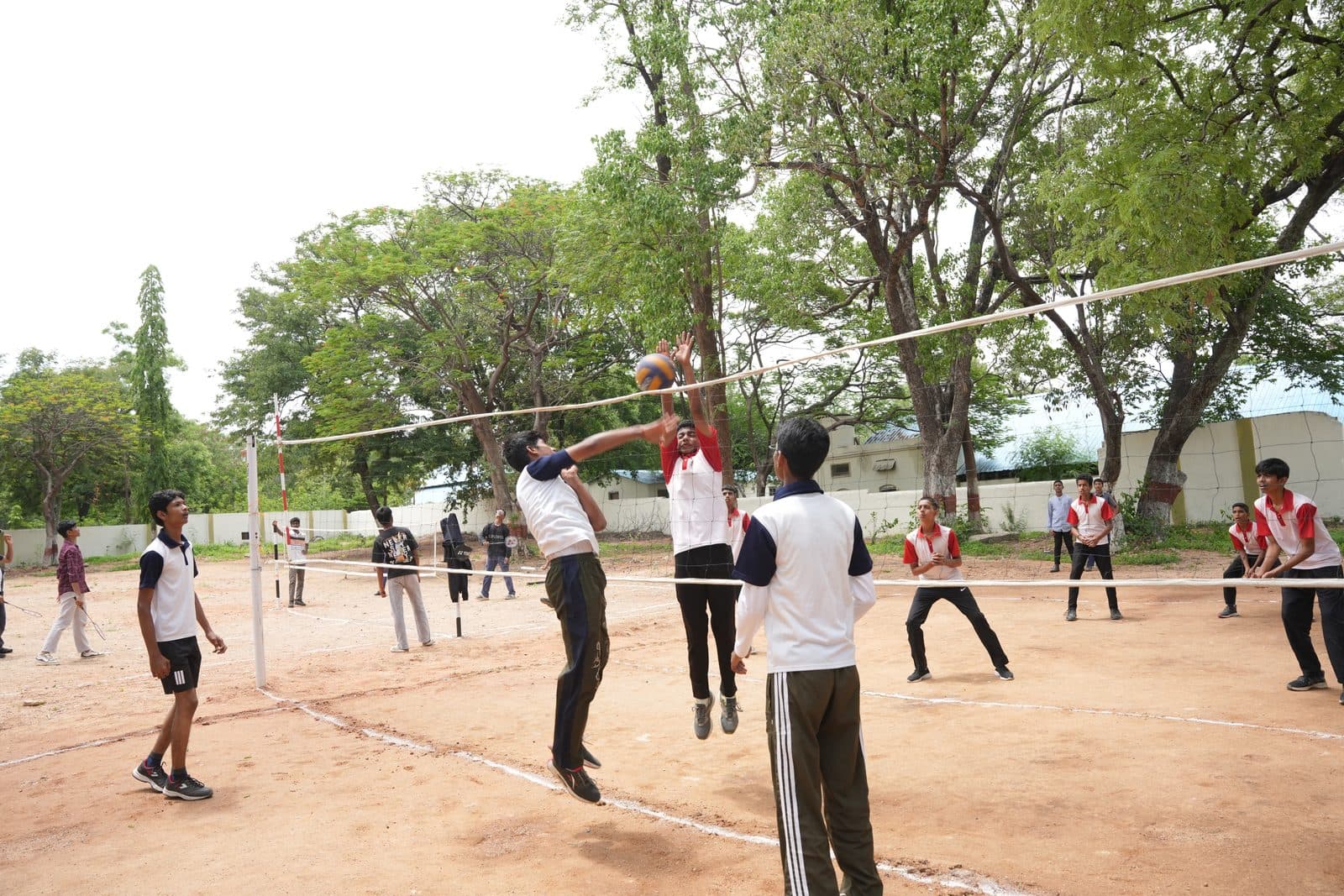 A student leaping at the net to spike the ball during a volleyball match